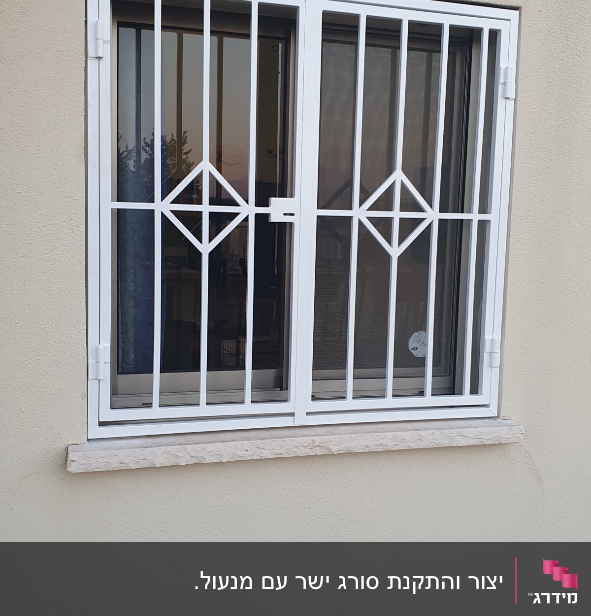 חלון עם סורגים לבנים על קיר חיצוני